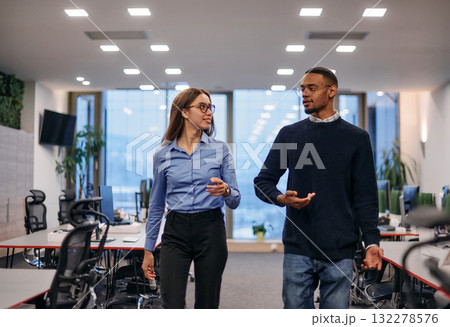 Dynamic Business Collaboration: Blonde Businesswoman and African American Colleague in Modern Office Setting. Dynamic Business Collaboration: Blonde Businesswoman and African American Colleague in Modern Office Setting. 132278576