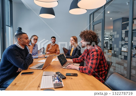 In the vibrant ambiance of a modern startup office, a diverse team of business professionals engage in discussions on various projects and develop new business strategies, epitomizing creativity and In the vibrant ambiance of a modern startup office, a diverse team of business professionals engage in discussions on various projects and develop new business strategies, epitomizing creativity and 132278719