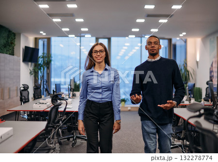 Dynamic Business Collaboration: Blonde Businesswoman and African American Colleague in Modern Office Setting. Dynamic Business Collaboration: Blonde Businesswoman and African American Colleague in Modern Office Setting. 132278774