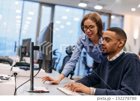 Digital Collaboration: Blonde Businesswoman and African American Partner Reviewing Documents Online 132278780