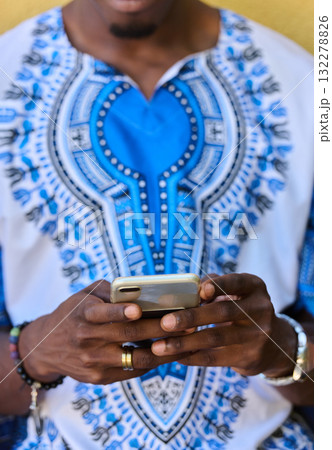 African American Teenager in Traditional Sudanese Attire Engaged with Smartphone African American Teenager in Traditional Sudanese Attire Engaged with Smartphone 132278826