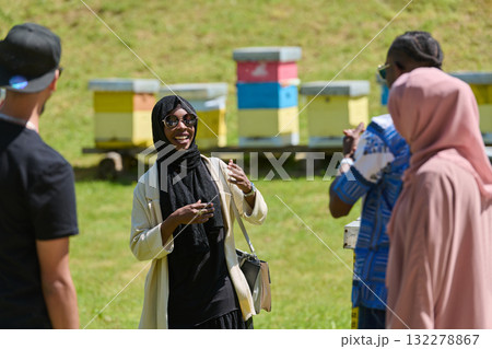 A diverse group of young friends and entrepreneurs explore small honey production businesses in the natural setting of the countryside. A diverse group of young friends and entrepreneurs explore small honey production businesses in the natural setting of the countryside. 132278867