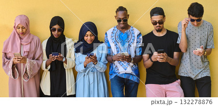 Diverse Teen Group Standing Together Against Wall Using Smartphones Diverse Teen Group Standing Together Against Wall Using Smartphones 132278876