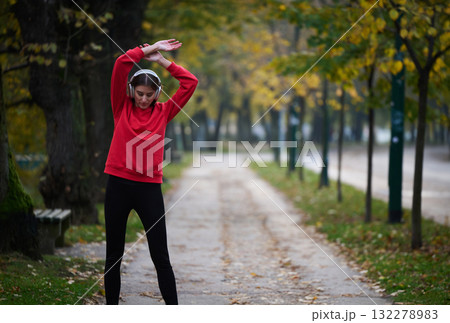Athletic young woman taking a breath and relaxing after jogging and stretching. Woman Training and Workout Exercises On Street. Athletic young woman taking a breath and relaxing after jogging and stretching. Woman Training and Workout Exercises On Street. 132278983