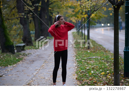 Athletic young woman taking a breath and relaxing after jogging and stretching. Woman Training and Workout Exercises On Street. 132278987