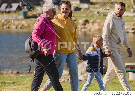 A family shares delightful moments with their friends amid the stunning landscapes of mountains, lakes, and winding paths, promoting a healthy lifestyle and the joy of familial bonds in the embrace of A family shares delightful moments with their friends amid the stunning landscapes of mountains, lakes, and winding paths, promoting a healthy lifestyle and the joy of familial bonds in the embrace of 132279109