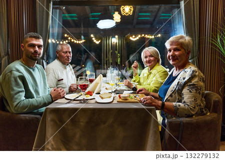 A group of family friends, comprising a young grandson and older individuals, share a delightful dinner in a modern restaurant, exemplifying the concept of healthy aging through intergenerational A group of family friends, comprising a young grandson and older individuals, share a delightful dinner in a modern restaurant, exemplifying the concept of healthy aging through intergenerational 132279132