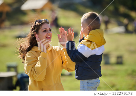 A mother and son create cherished memories as they playfully engage in outdoor activities, their laughter echoing the joy of shared moments and the bond between parent and child A mother and son create cherished memories as they playfully engage in outdoor activities, their laughter echoing the joy of shared moments and the bond between parent and child 132279178