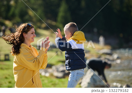 A mother and son create cherished memories as they playfully engage in outdoor activities, their laughter echoing the joy of shared moments and the bond between parent and child A mother and son create cherished memories as they playfully engage in outdoor activities, their laughter echoing the joy of shared moments and the bond between parent and child 132279182