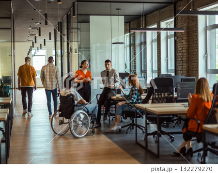 A diverse group of young business individuals congregates in a modern startup coworking center, embodying collaborative innovation and a dynamic atmosphere A diverse group of young business individuals congregates in a modern startup coworking center, embodying collaborative innovation and a dynamic atmosphere 132279270