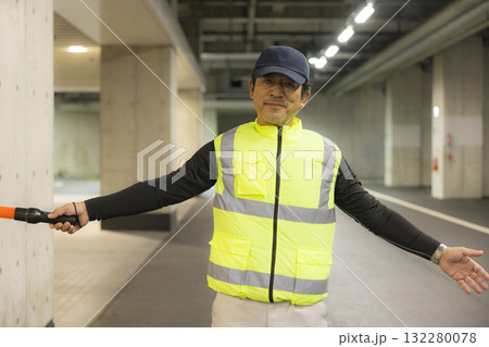 地下駐車場で誘導する男性 132280078