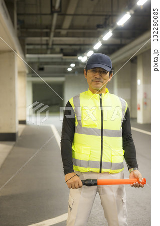 地下駐車場で誘導する男性 132280085
