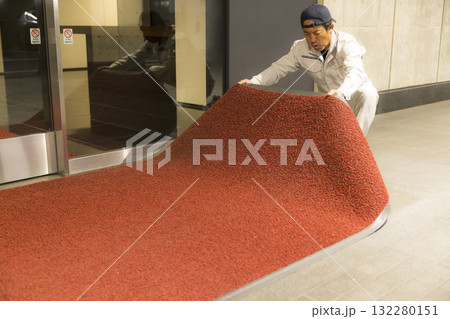 オフィスのエントランスでマットを交換する業者の男性 オフィスのエントランスでマットを交換する業者の男性 132280151