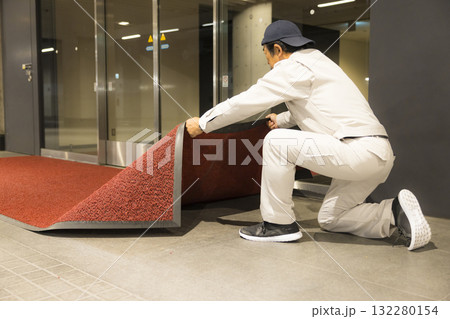 オフィスのエントランスでマットを交換する業者の男性 オフィスのエントランスでマットを交換する業者の男性 132280154