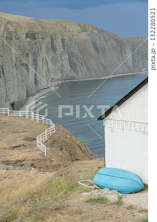 Coastal View of Cliffs and a Boat Near a White House by the Sea Coastal View of Cliffs and a Boat Near a White House by the Sea 132280521