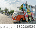 Colorful Surfboards and a Vintage Van on a Sunny Waterfront Promenade 132280529