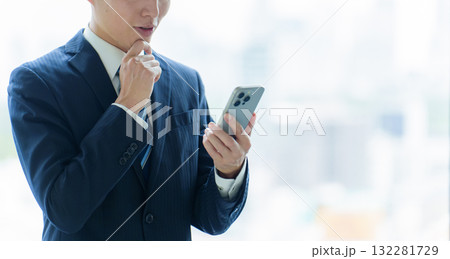 困った表情でスマートフォンを使うビジネスマン 132281729