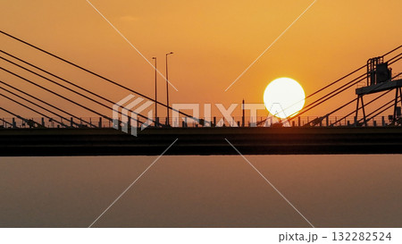 Oct 7 2025 Sunset Over Bridge With Silhouetted Bus, Cables, And Industrial Structures 132282524