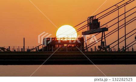 Oct 7 2025 Sunset Over Bridge With Silhouetted Bus, Cables, And Industrial Structures 132282525