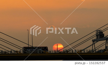 Oct 7 2025 Sunset Over Bridge With Silhouetted Bus, Cables, And Industrial Structures 132282537