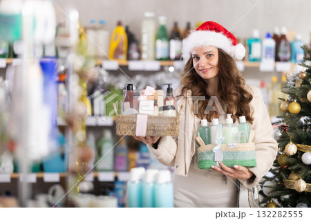 Young woman buyer chooses cosmetics gift set for christmas Young woman buyer chooses cosmetics gift set for christmas 132282555