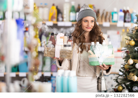 In household chemicals store, woman examines composition of shower cosmetic kit, X Mas gift set 132282566