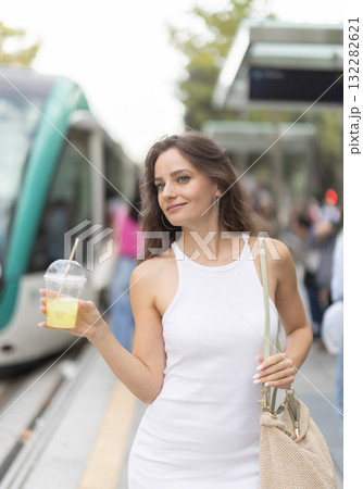Young woman with glass of slush at subway station Young woman with glass of slush at subway station 132282621