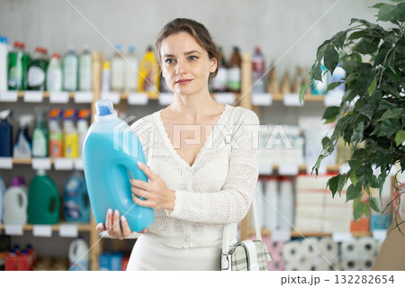 Young woman buyer chooses detergent in store 132282654