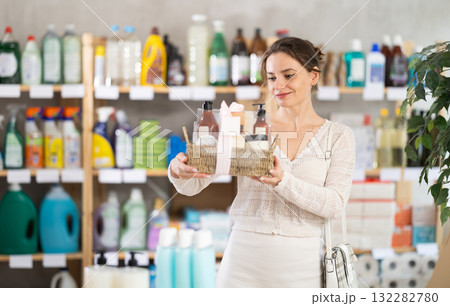 In household chemicals store, woman examines composition of shower cosmetic kit. 132282780