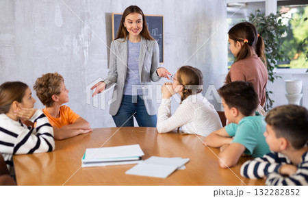 Portrait of female teacher giving lesson to children in school class 132282852