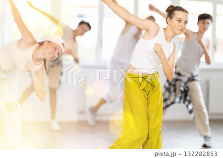 Teenage girl practicing hip hop slide moves in training hall 132282853
