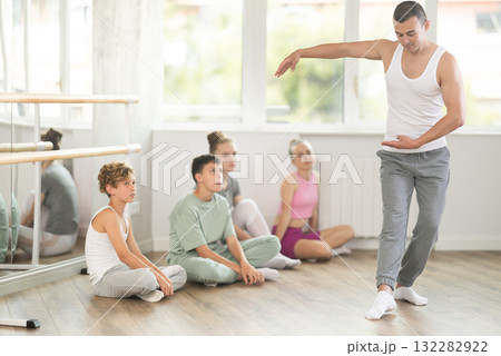 Teen visitors to choreographic class, observe professional rendering of dance performances couch 132282922