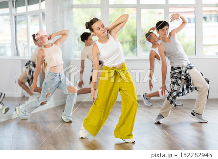 Teenage girl practicing hip-hop backbend moves in training hall 132282945