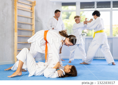 Group of children in kimono practicing karate in a sports gym. Martial arts training session 132283017