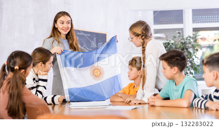 Teacher showing Argentina flag to group of schoolchildren Teacher showing Argentina flag to group of schoolchildren 132283022