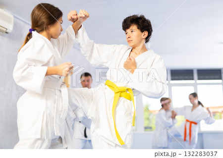 Boy and girl training karate techniques in studio 132283037