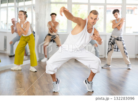 Young guy dancing hip-hop against background of group members 132283096