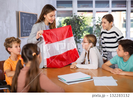Teacher showing Austria flag to group of preteen schoolchildren Teacher showing Austria flag to group of preteen schoolchildren 132283132