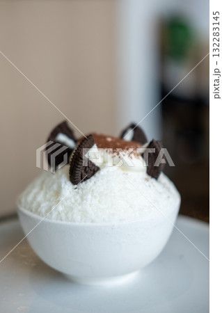 Shaved ice or Bingsu with chocolate powder and cookie on the top, served in a bowl 132283145