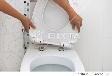 Handyman replace toilet seat cover.  Bathroom toilet seat replacement concept. 132284998