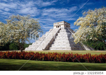 Ancient Mayan Ruins of Chichen Itza with Pyramid Temple Surrounded by Clear Sky and Lush Greenery in Mexico 132285054