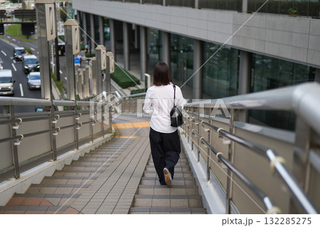 歩道橋の階段を降りるビジネスウーマンの後ろ姿 132285275