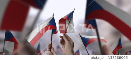 Czechia flags in their hands on a blurred urban background 132286006
