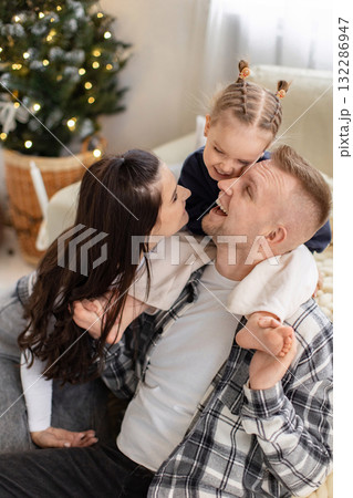 A happy family shares a moment of laughter and love, with the daughter on her father's shoulders. A happy family shares a moment of laughter and love, with the daughter on her father's shoulders. 132286947