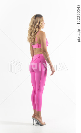 Athletic woman posing in pink sportswear on white background Athletic woman posing in pink sportswear on white background 132290548