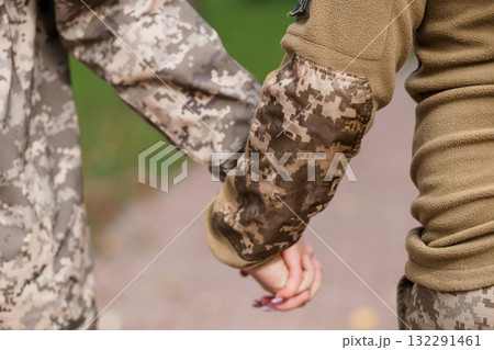 Camouflaged Arms Holding Cigarette, Military Clothing, Brown and Green Tones, Outdoor Scene, Tactical Gear, Close-up Shot, Realistic Texture. Camouflaged Arms Holding Cigarette, Military Clothing, Brown and Green Tones, Outdoor Scene, Tactical Gear, Close-up Shot, Realistic Texture. 132291461