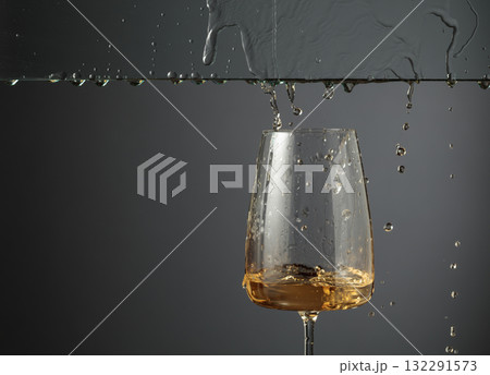 White wine flows down into a glass. White wine flows down into a glass. 132291573
