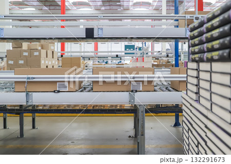 packing line in a logistics warehouse. conveyor belt in a modern production line packing line in a logistics warehouse. conveyor belt in a modern production line 132291673