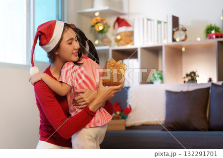 Emotional Embrace. Mother hugging her daughter after giving a Christmas gift. Emotional Embrace. Mother hugging her daughter after giving a Christmas gift. 132291701
