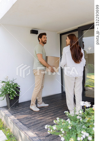 Couple carrying cardboard boxes while moving to a new house 132293699